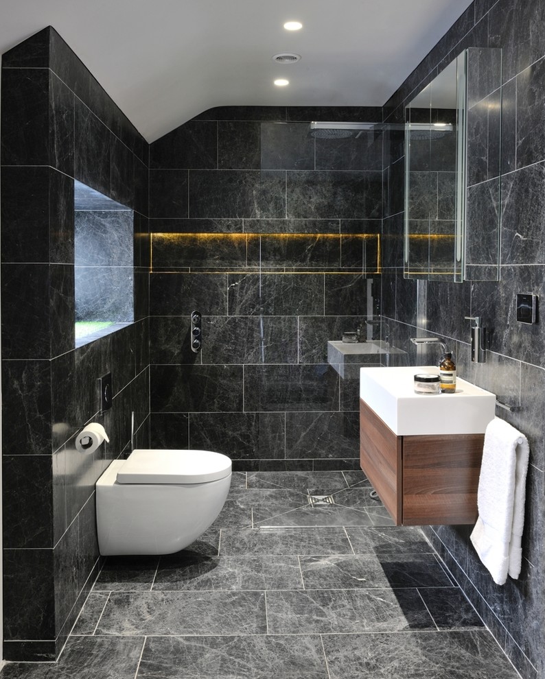 Inspiration for a contemporary cloakroom in Other with flat-panel cabinets, medium wood cabinets, a wall mounted toilet, a vessel sink and marble tiles.