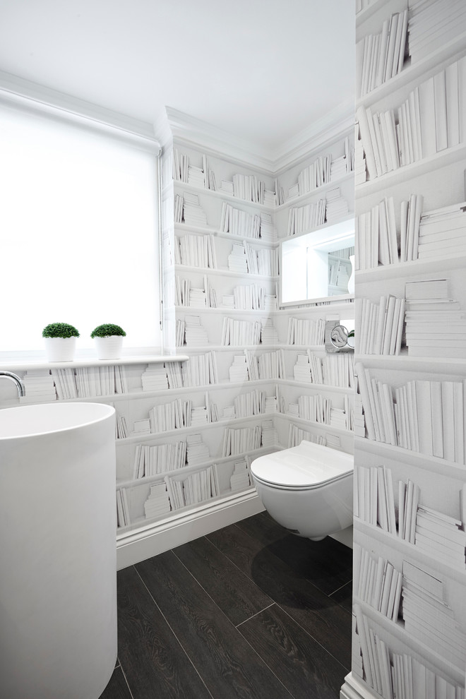 Diseño de aseo contemporáneo pequeño con lavabo con pedestal, sanitario de pared, paredes grises y suelo de madera oscura