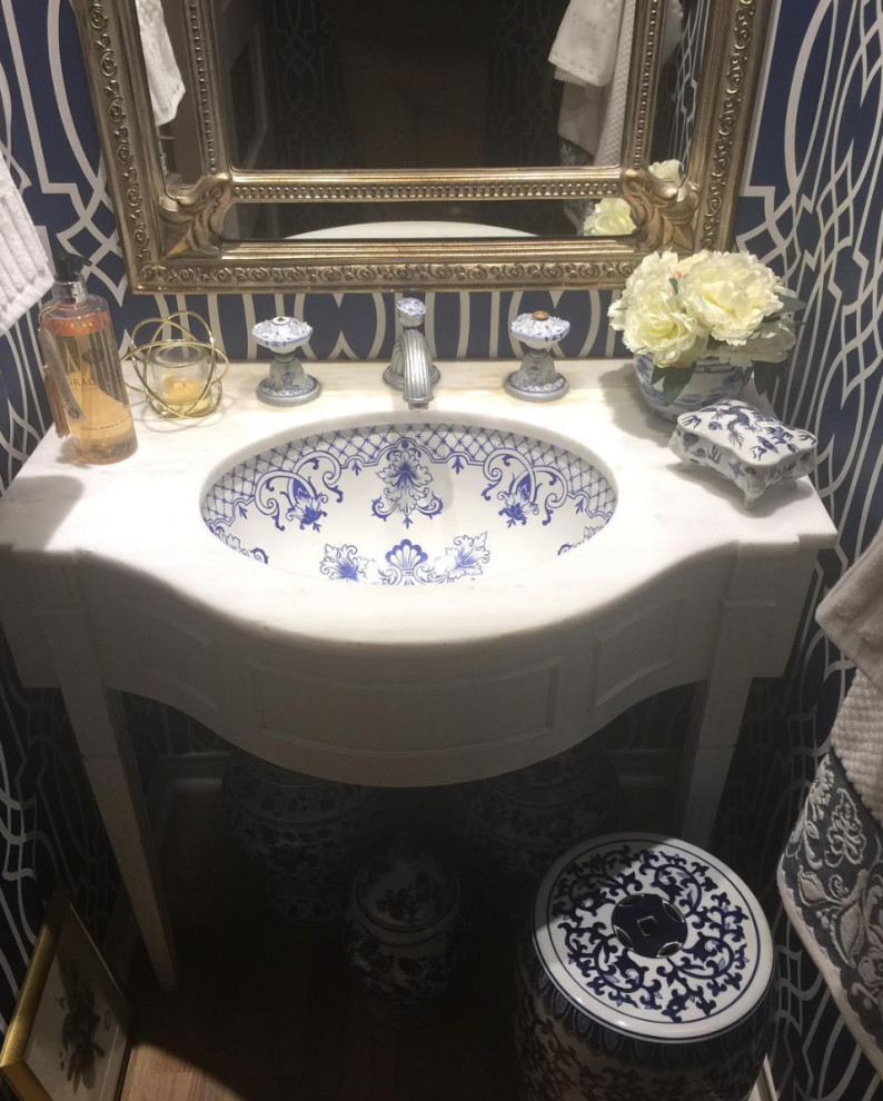 Idée de décoration pour un petit WC et toilettes bohème avec un mur bleu, parquet clair, un plan vasque et un sol gris.