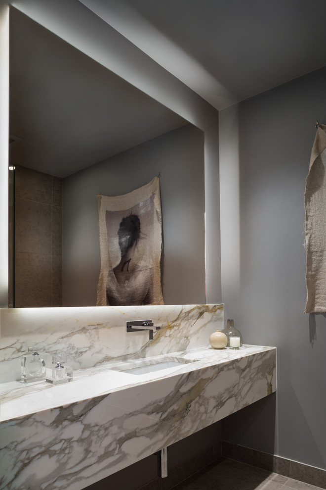 Esempio di un bagno di servizio minimal di medie dimensioni con WC sospeso, pareti grigie, pavimento in gres porcellanato, lavabo sospeso e top in marmo