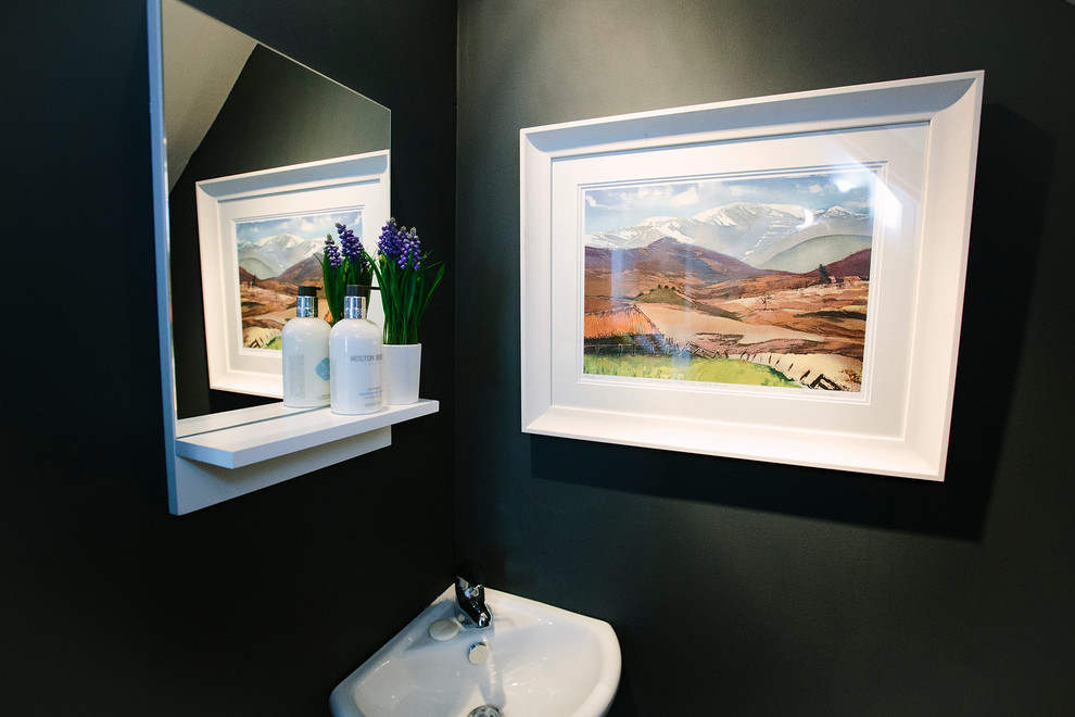 This is an example of a small contemporary cloakroom in London with black walls.