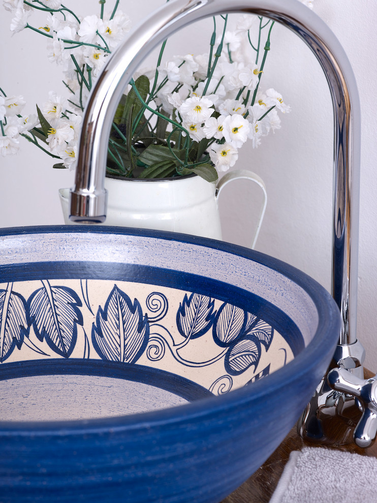 Diseño de aseo bohemio de tamaño medio con baldosas y/o azulejos blancos, lavabo sobreencimera y encimera de madera