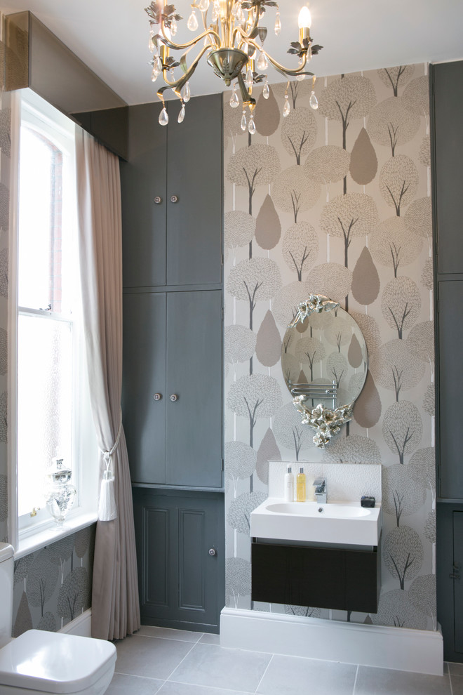 На фото: большой туалет в стиле неоклассика (современная классика) с серыми фасадами, серой плиткой, раздельным унитазом, серыми стенами, серым полом и монолитной раковиной