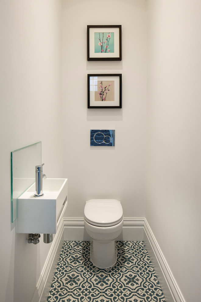 Inspiration for a small classic cloakroom in London with a two-piece toilet, porcelain flooring, a wall-mounted sink, flat-panel cabinets, white cabinets, multi-coloured floors, a feature wall and a floating vanity unit.