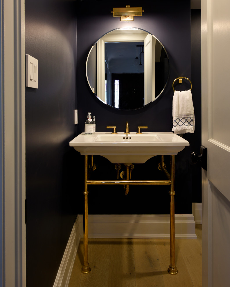 Example of a small transitional light wood floor powder room design in Ottawa with blue walls and a console sink
