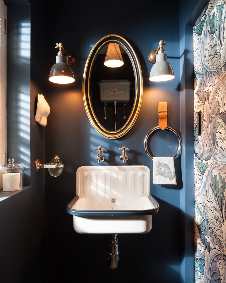 Idée de décoration pour un WC et toilettes champêtre avec un mur bleu et un lavabo suspendu.