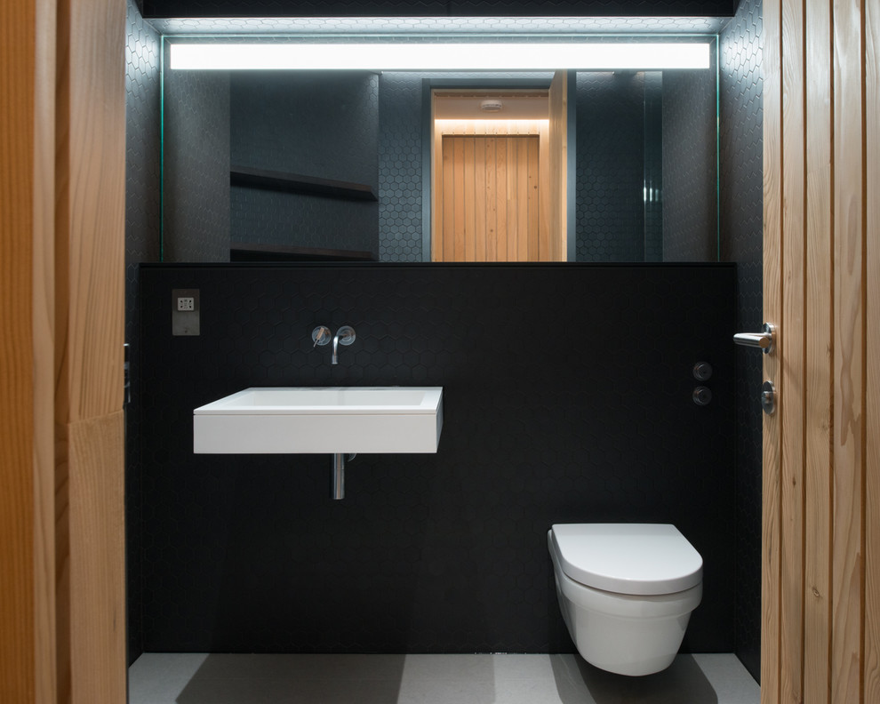Пример оригинального дизайна: маленький туалет в современном стиле с черной плиткой и белым полом для на участке и в саду