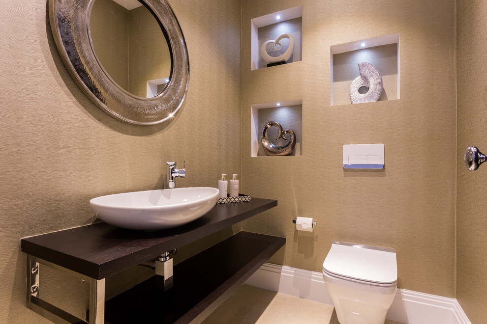 Exemple d'un WC suspendu tendance en bois foncé de taille moyenne avec un placard sans porte, un plan de toilette en bois, un sol beige, un plan de toilette marron, un mur beige et une vasque.
