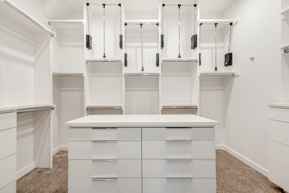 Diseño de armario vestidor unisex minimalista con armarios con paneles lisos, puertas de armario blancas, suelo de cemento y suelo gris