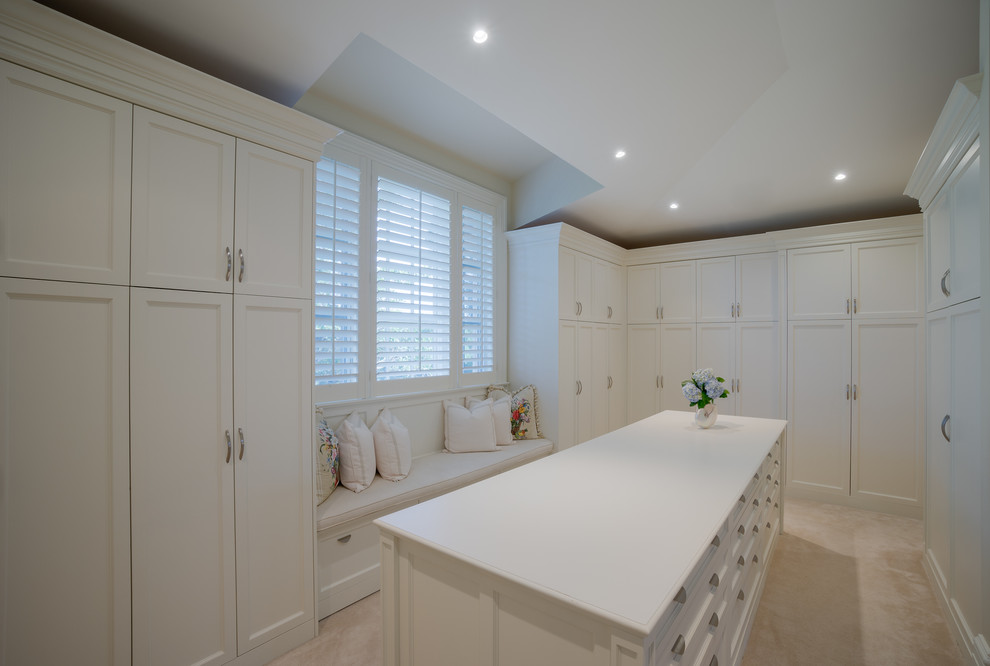 Example of a huge transitional gender-neutral carpeted walk-in closet design in Miami with white cabinets and recessed-panel cabinets