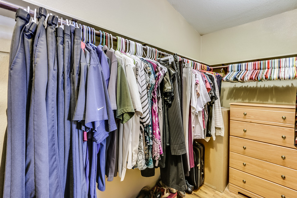 Foto de armario vestidor unisex de estilo americano de tamaño medio con armarios abiertos, puertas de armario blancas y suelo de madera en tonos medios