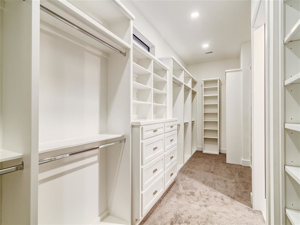Inspiration for a medium sized modern gender neutral walk-in wardrobe in Houston with shaker cabinets, carpet and white cabinets.