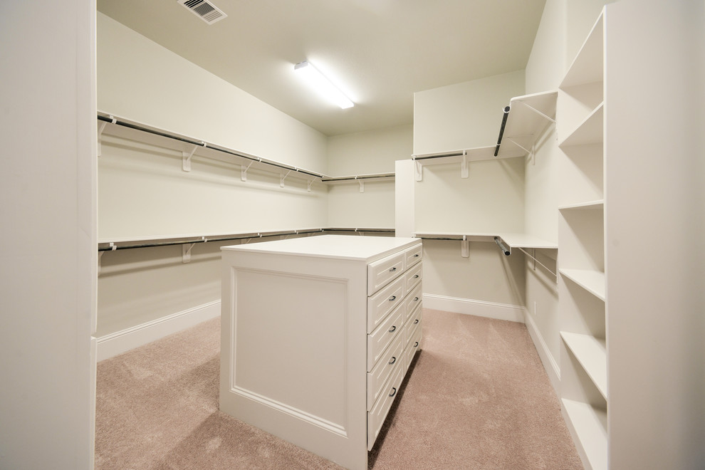 Design ideas for a large traditional gender neutral walk-in wardrobe in Houston with raised-panel cabinets, white cabinets and carpet.