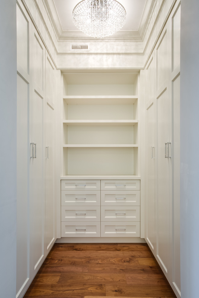 Foto de armario vestidor de hombre actual pequeño con armarios estilo shaker, puertas de armario blancas y suelo de madera en tonos medios