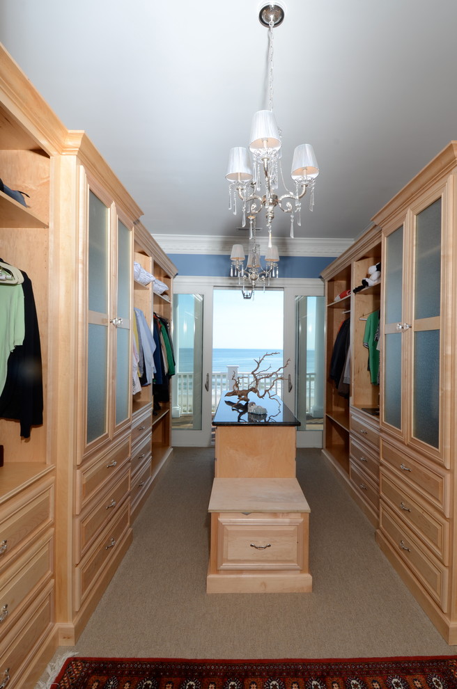 Modelo de vestidor unisex costero grande con armarios abiertos, puertas de armario de madera clara, moqueta y suelo beige