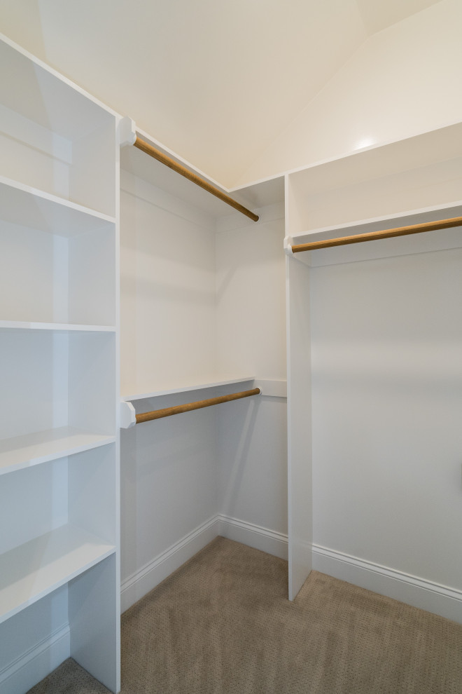 This is an example of a medium sized rural gender neutral walk-in wardrobe in Raleigh with carpet and grey floors.