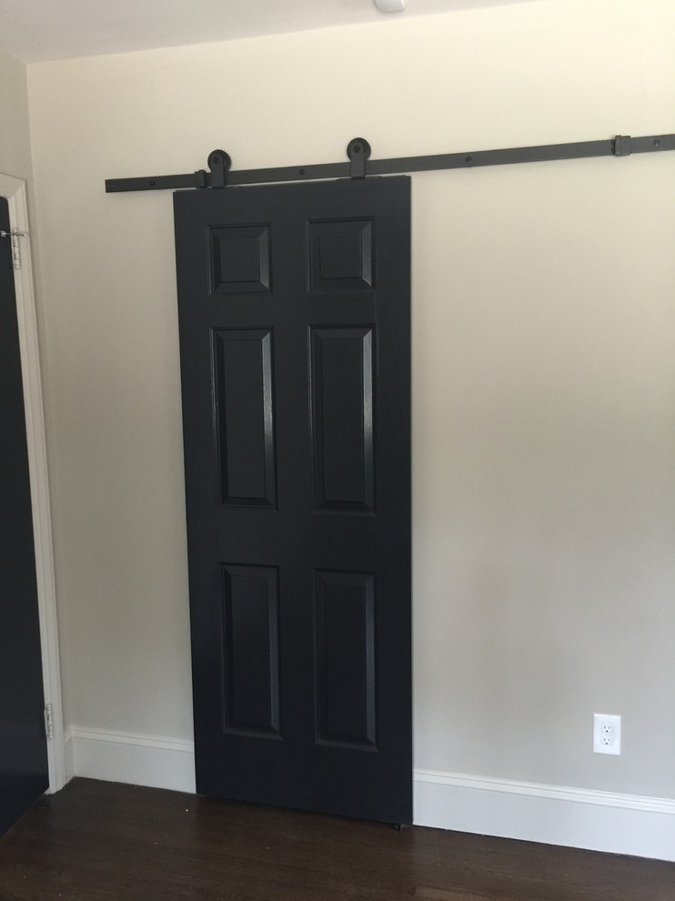 This is an example of a contemporary wardrobe in Charlotte with dark hardwood flooring.