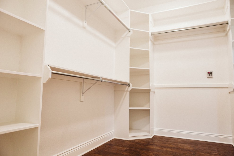 Ejemplo de armario vestidor unisex tradicional renovado de tamaño medio con armarios abiertos, puertas de armario blancas, suelo de madera oscura y suelo marrón
