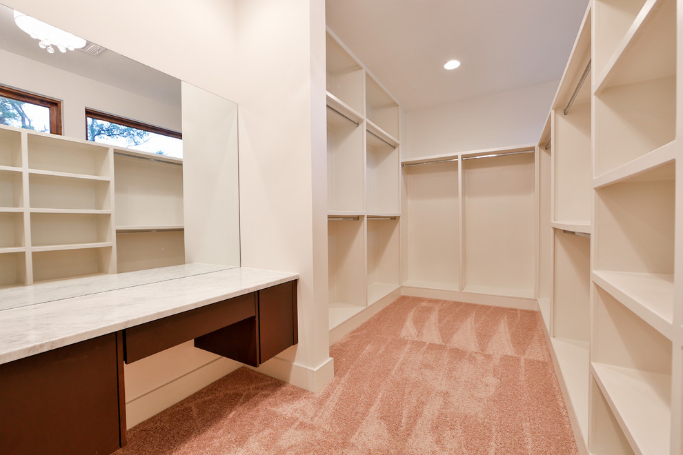 Пример оригинального дизайна: большая гардеробная комната в современном стиле с ковровым покрытием для женщин