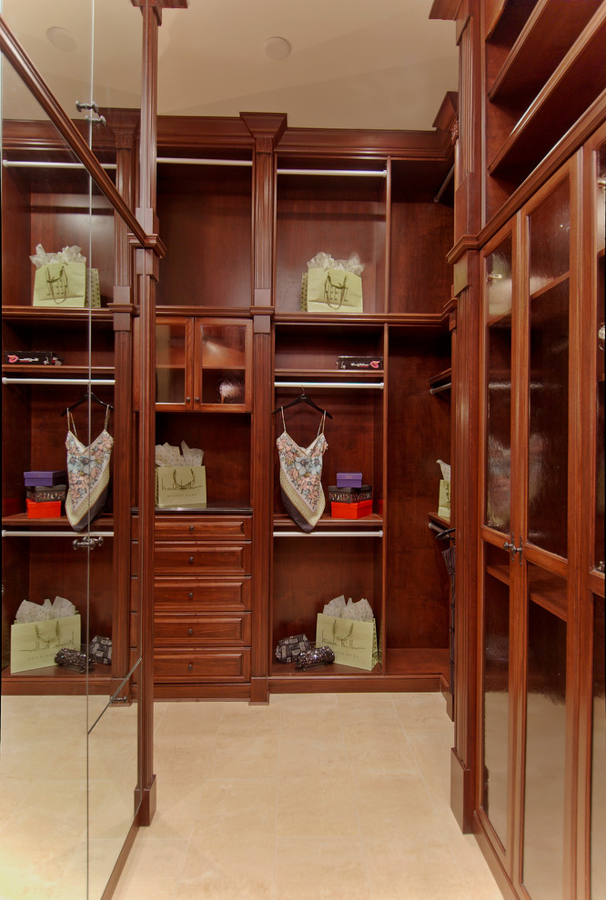 Imagen de armario vestidor unisex mediterráneo grande con armarios con paneles con relieve, puertas de armario de madera oscura y suelo de baldosas de cerámica