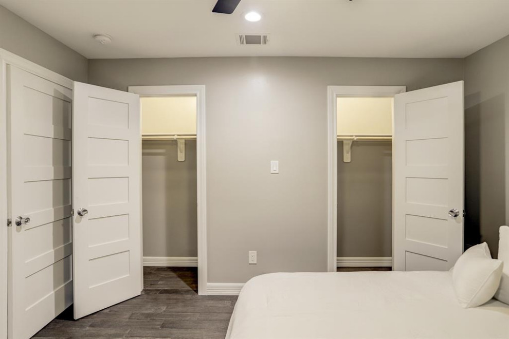 Foto de armario unisex moderno de tamaño medio con puertas de armario blancas, suelo de madera en tonos medios y suelo gris