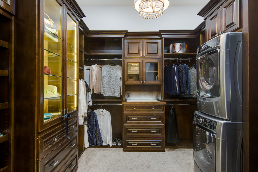 Modelo de armario y vestidor clásico con armarios con paneles con relieve, puertas de armario de madera en tonos medios, moqueta y suelo gris