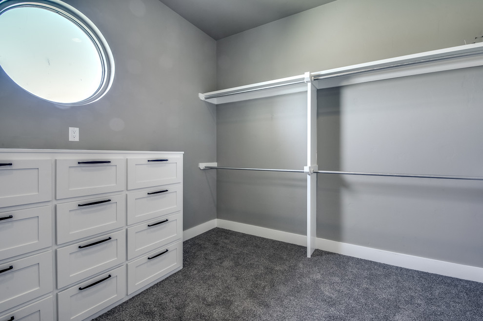 На фото: гардеробная комната среднего размера, унисекс в классическом стиле с фасадами в стиле шейкер, белыми фасадами, ковровым покрытием и серым полом