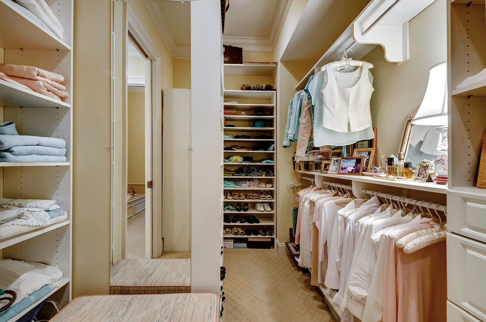 Imagen de vestidor unisex clásico con armarios abiertos, puertas de armario blancas y moqueta