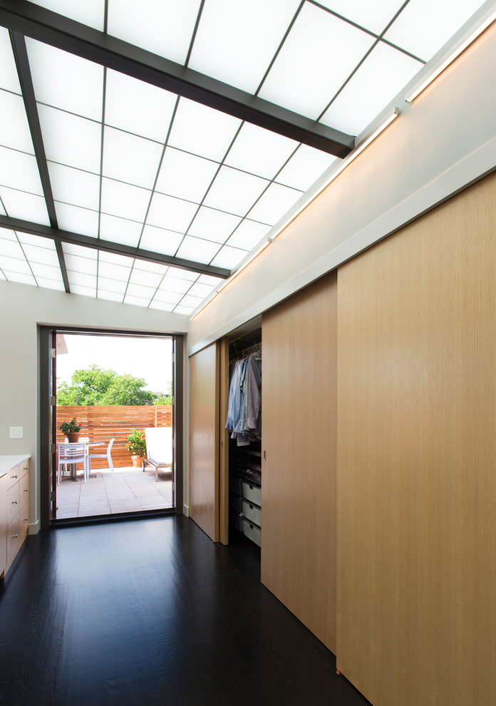 Aménagement d'un dressing room contemporain en bois clair de taille moyenne et neutre avec un placard à porte plane et parquet foncé.
