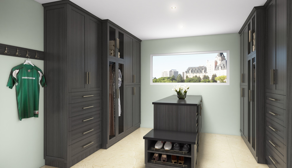 Photo of a large walk-in wardrobe for men in Calgary with glass-front cabinets and grey cabinets.