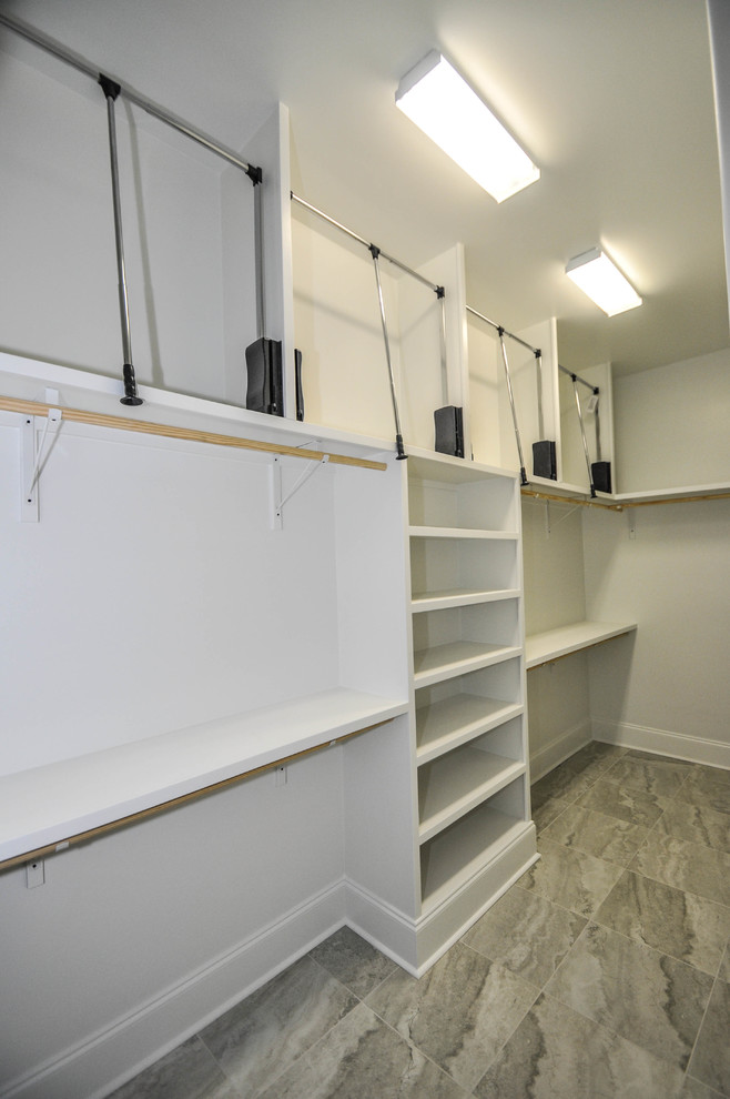 This is an example of a medium sized classic gender neutral walk-in wardrobe in New Orleans with ceramic flooring.