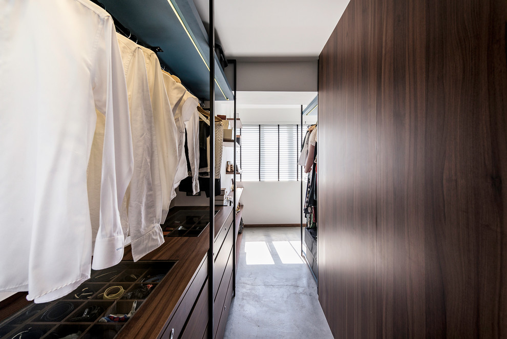 Ejemplo de armario vestidor unisex actual con armarios con paneles lisos, puertas de armario de madera en tonos medios, suelo de cemento y suelo gris