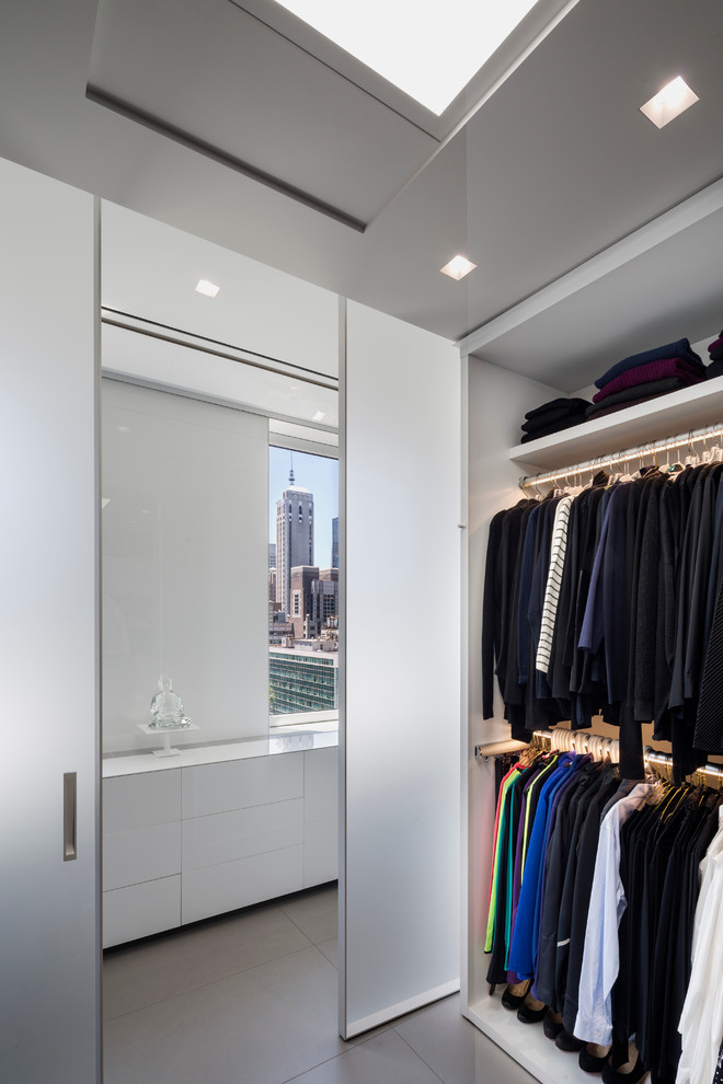 На фото: гардеробная комната унисекс в современном стиле с серым полом