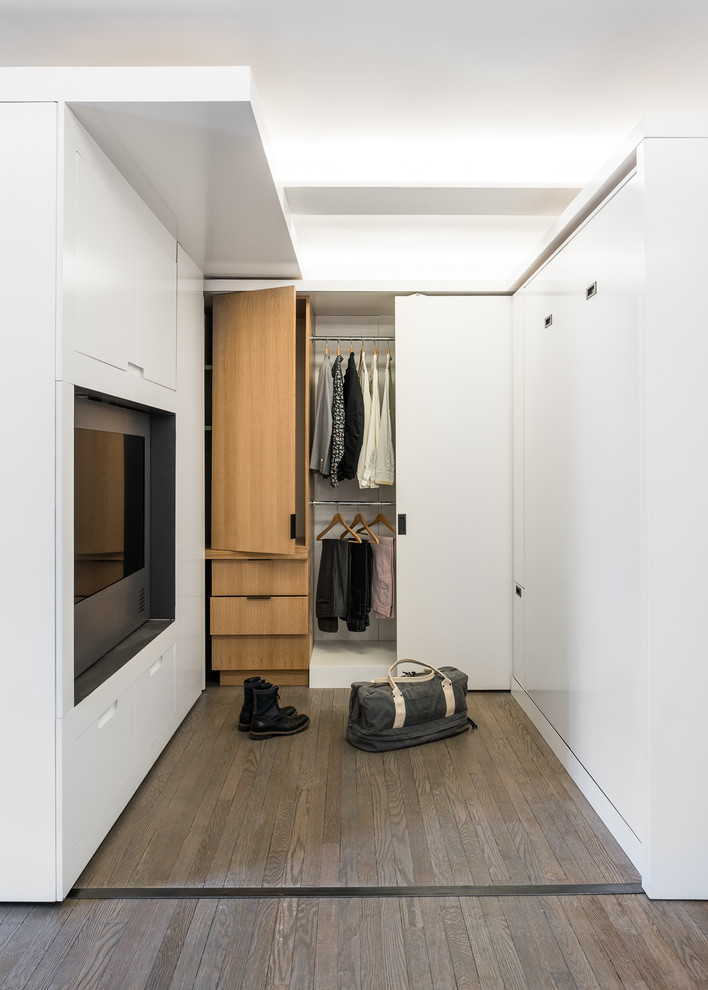 Foto di un piccolo spazio per vestirsi unisex minimalista con ante lisce, ante in legno chiaro e pavimento in legno massello medio