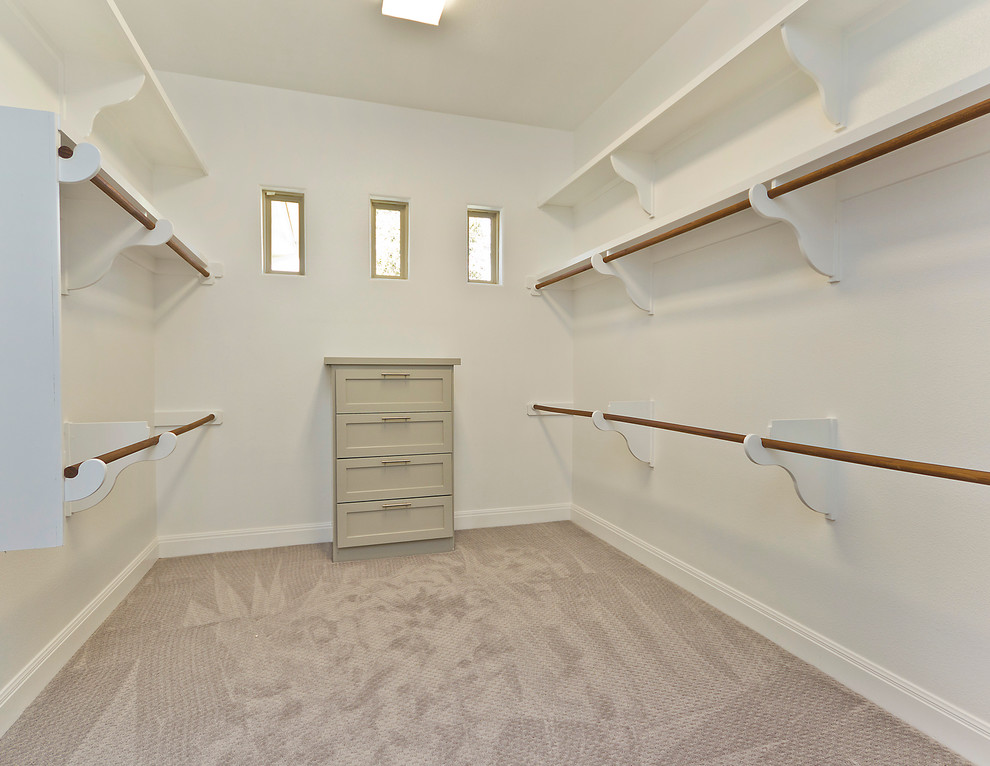 Idée de décoration pour un dressing room tradition de taille moyenne et neutre avec un placard à porte shaker, des portes de placard beiges et moquette.