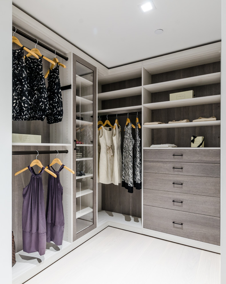 Expansive modern gender neutral walk-in wardrobe in New York with white floors.