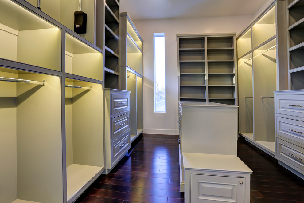 Inspiration for a large classic gender neutral walk-in wardrobe in Houston with recessed-panel cabinets, grey cabinets and dark hardwood flooring.