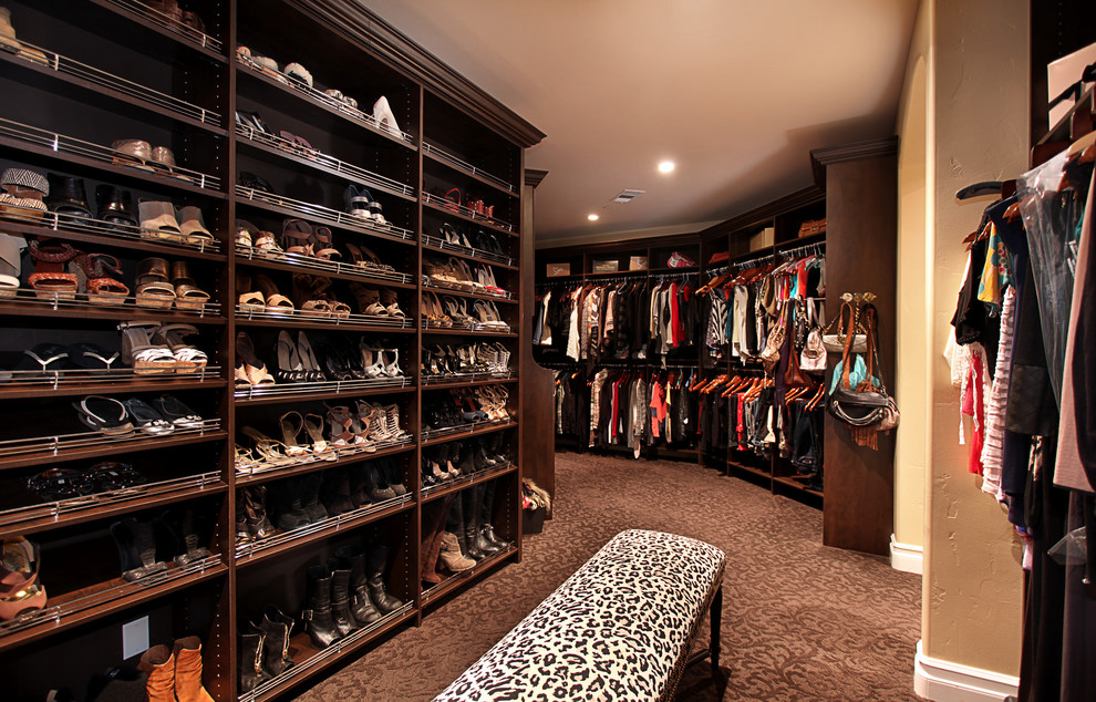 Huge tuscan women's carpeted walk-in closet photo in Orange County with open cabinets and dark wood cabinets