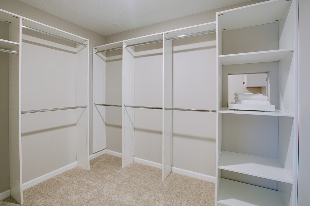 Пример оригинального дизайна: большая гардеробная комната унисекс в стиле неоклассика (современная классика) с открытыми фасадами, белыми фасадами, ковровым покрытием и бежевым полом