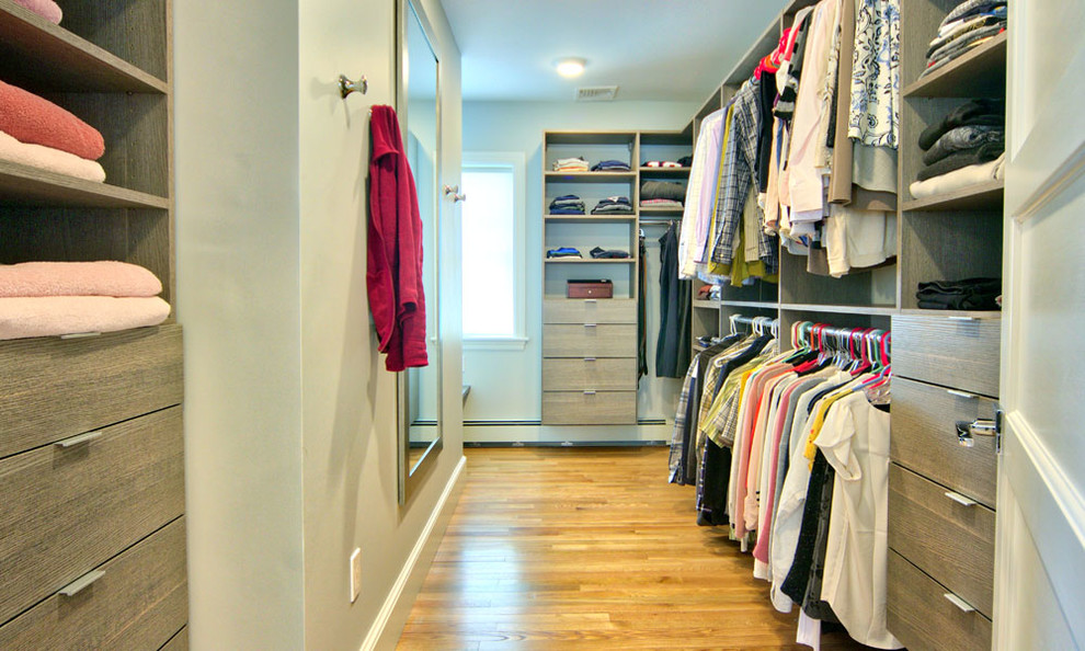 Imagen de vestidor unisex clásico renovado de tamaño medio con armarios con paneles lisos, puertas de armario de madera oscura y suelo de madera en tonos medios
