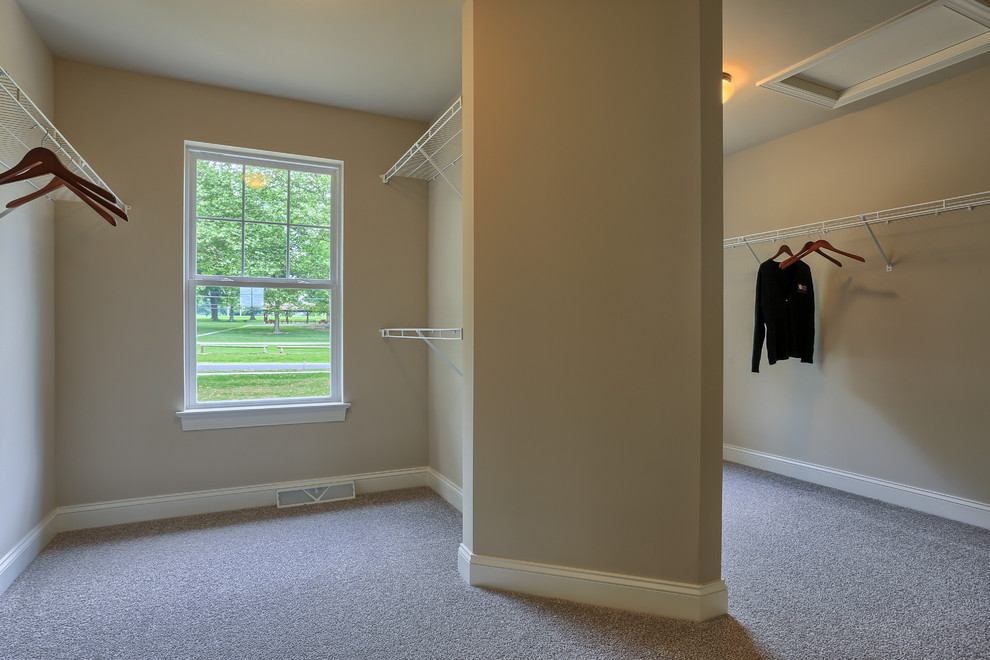 На фото: огромная гардеробная комната унисекс в стиле кантри с ковровым покрытием с