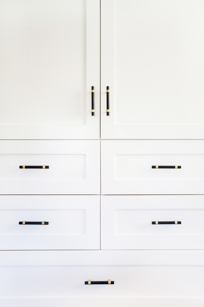 Design ideas for a medium sized modern gender neutral standard wardrobe in Los Angeles with shaker cabinets, white cabinets and light hardwood flooring.