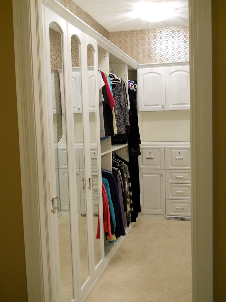 Ejemplo de armario vestidor de mujer contemporáneo grande con armarios con paneles con relieve, puertas de armario blancas y moqueta