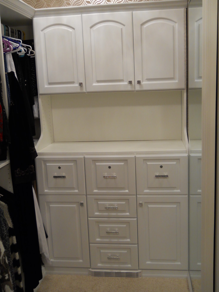 Large contemporary walk-in wardrobe for women in Cleveland with raised-panel cabinets, white cabinets and carpet.