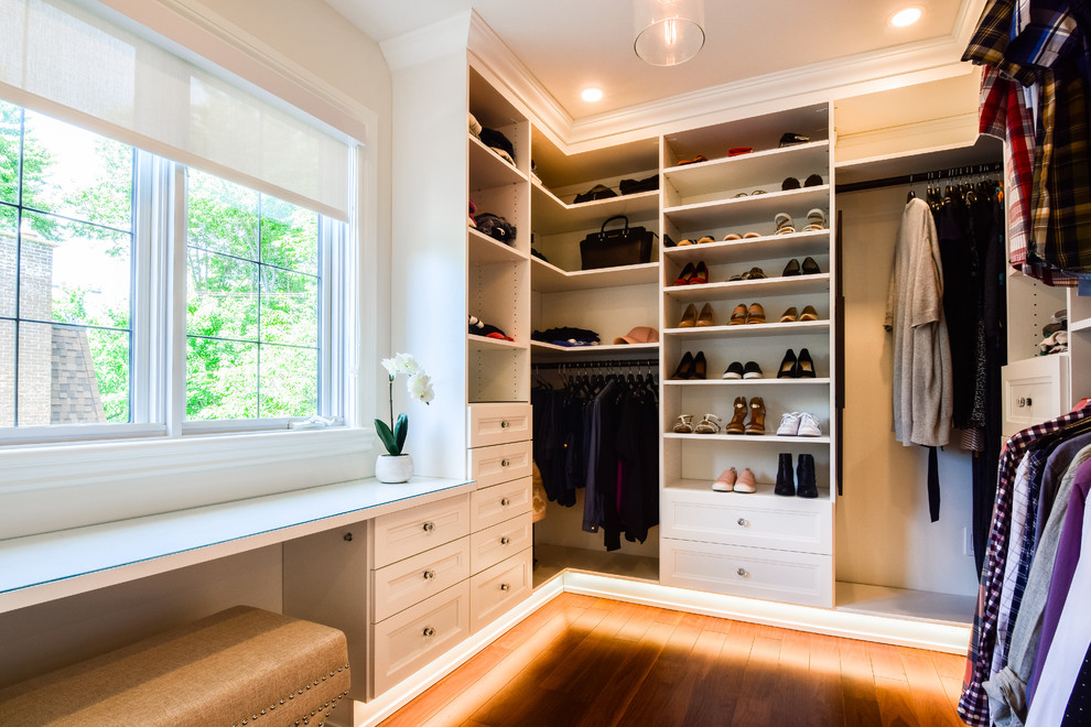 Design ideas for a large classic gender neutral walk-in wardrobe in Montreal with open cabinets, white cabinets, medium hardwood flooring and brown floors.