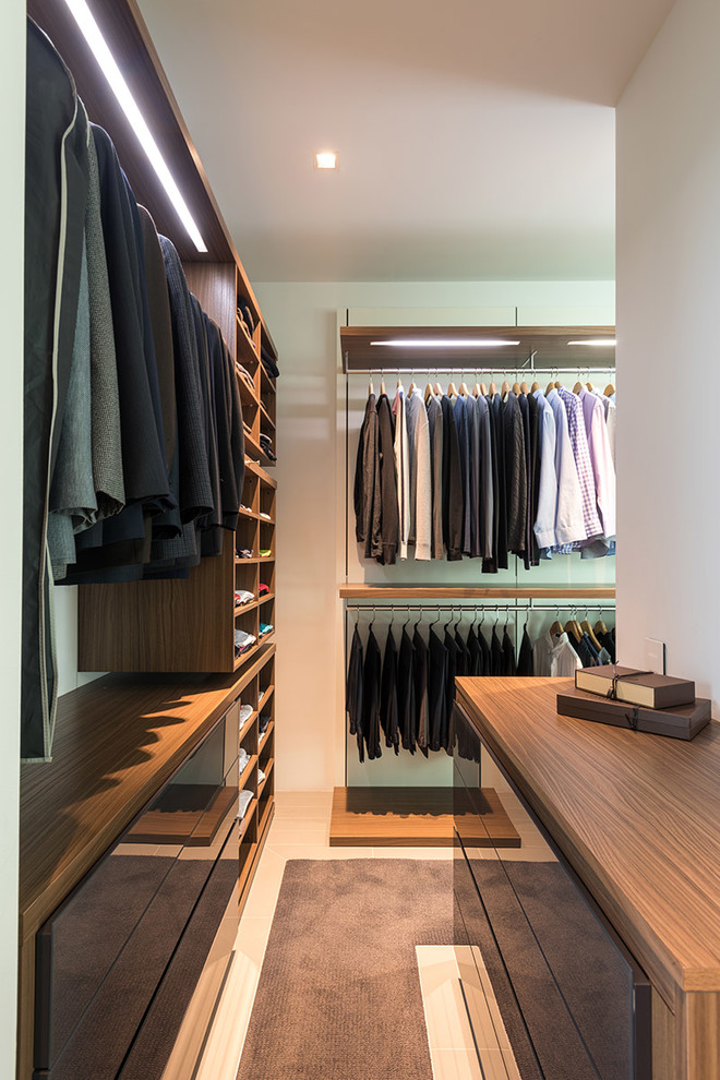 Стильный дизайн: гардеробная комната унисекс в стиле модернизм с открытыми фасадами, темными деревянными фасадами и ковровым покрытием - последний тренд