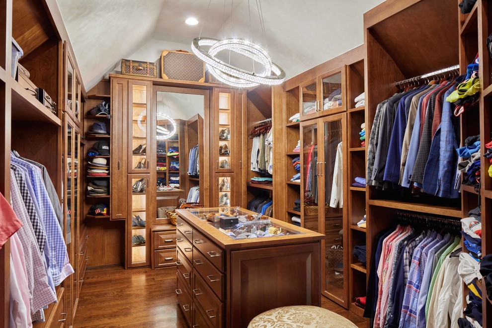 Ejemplo de armario vestidor de hombre clásico renovado con armarios abiertos, puertas de armario de madera oscura, suelo de madera en tonos medios y suelo marrón