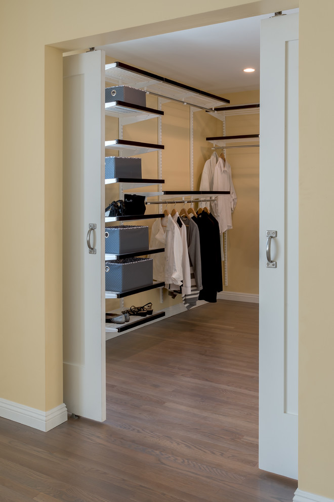 Идея дизайна: гардеробная комната среднего размера, унисекс в стиле неоклассика (современная классика) с полом из винила
