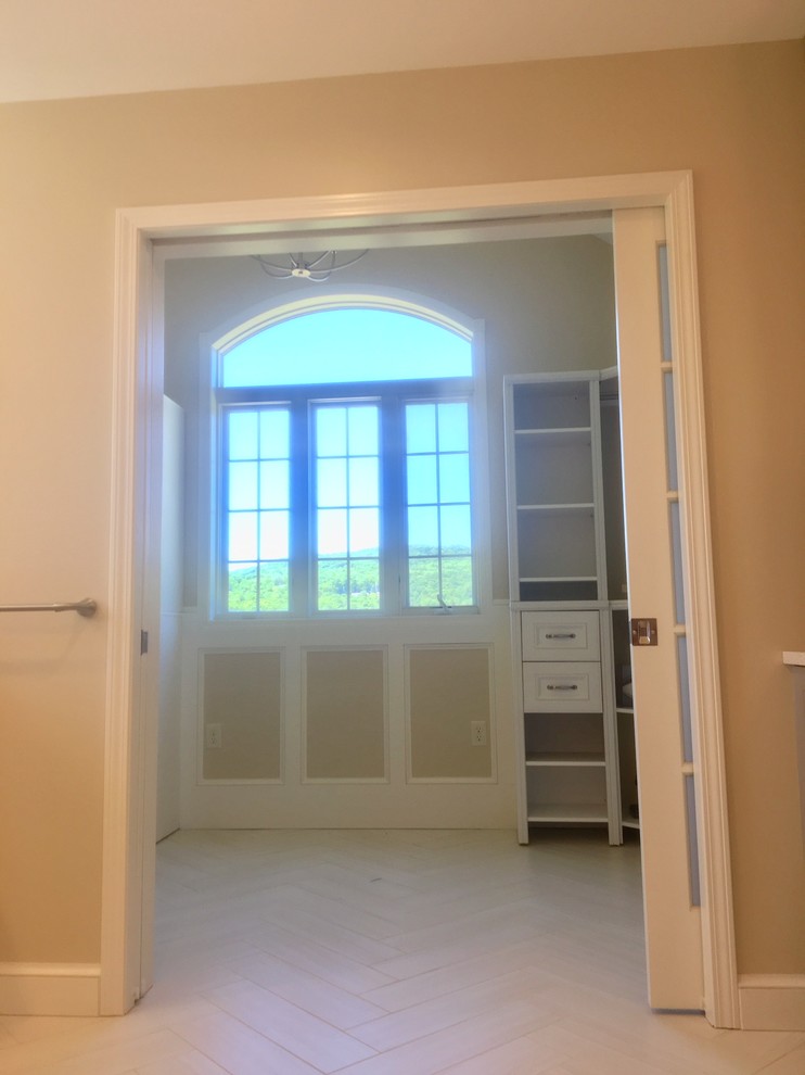 Modern inredning av ett litet walk-in-closet för könsneutrala, med öppna hyllor, vita skåp, klinkergolv i porslin och vitt golv