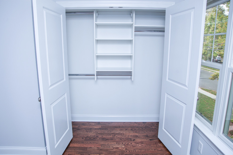 Foto de armario unisex clásico de tamaño medio con armarios abiertos, puertas de armario blancas y suelo de madera oscura